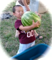 Tianning lugs a large watermelon to a picnic in Riverside Park - Schenectady NY - 21July2010