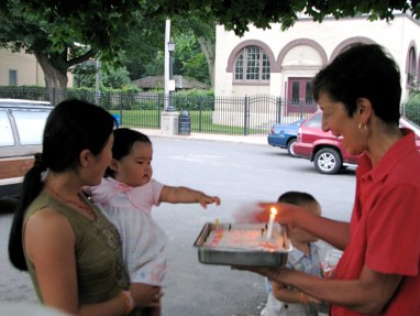 Xiwen points at her 1st birthday cake with the Pumphouse in the background at Riverside Park - Schenectady NY - 28July2010